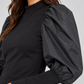 Maglia donna Imperial nera con maniche a sbuffo - dettaglio su modella, elaborata con IA