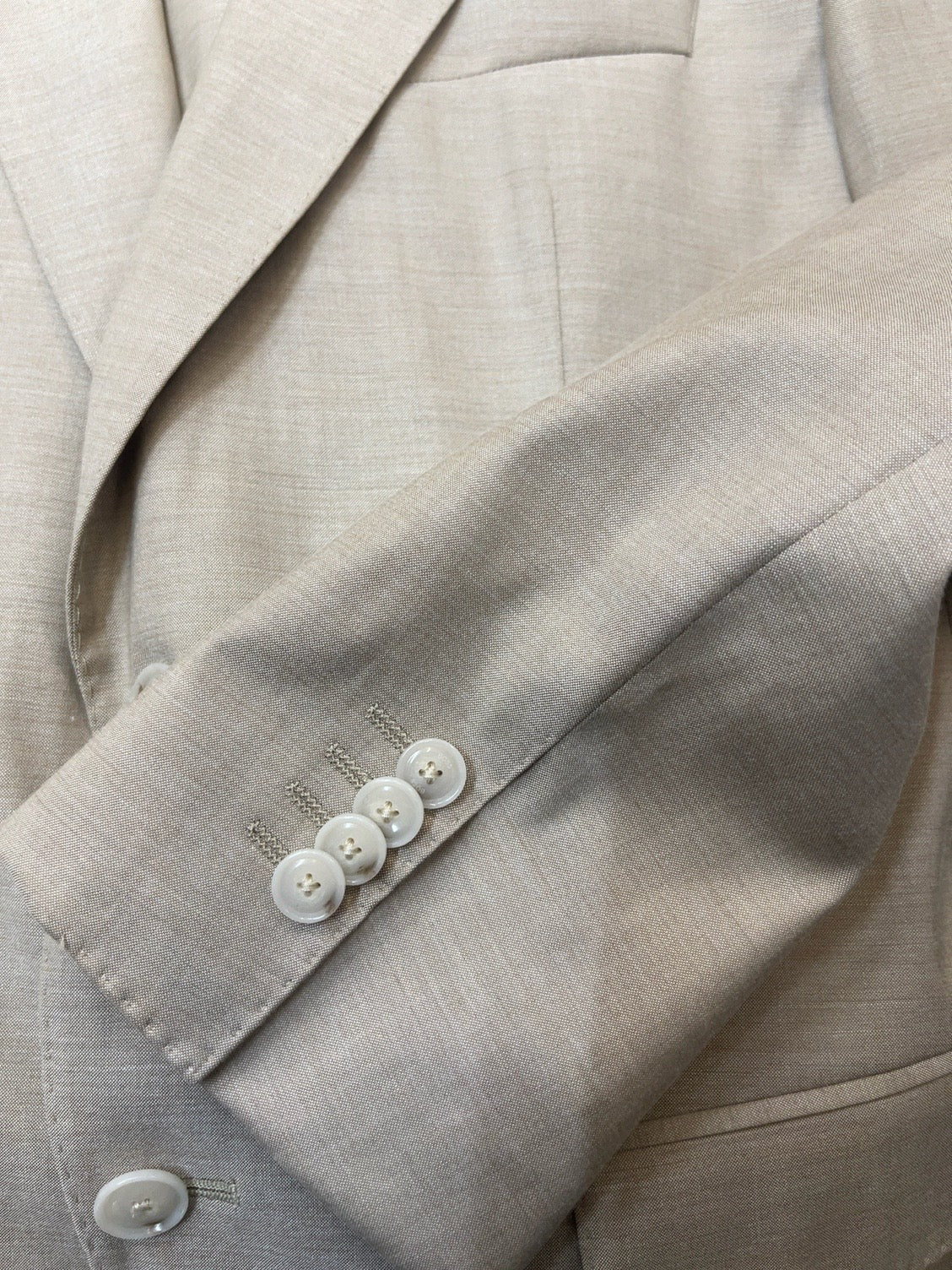 Dettaglio reale del tessuto e dei bottoni dell'abito Hugo Boss beige