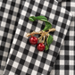 Tailleur Dixie a quadretti — dettaglio spilla con ciliegie