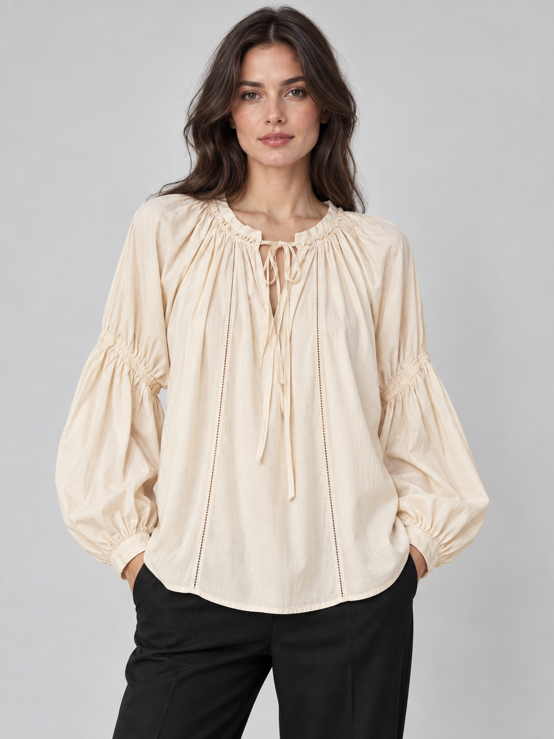 Blusa panna con scollo arricciato e laccetti, lunghe maniche morbide – fronte su modella