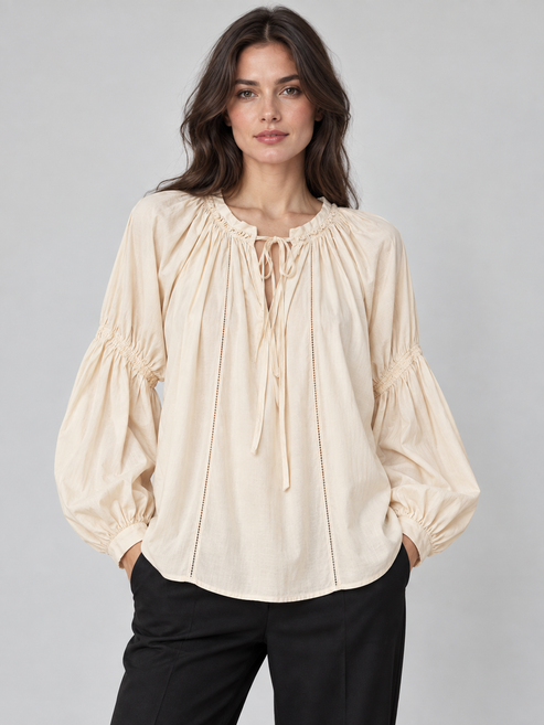 Blusa panna con scollo arricciato e laccetti, lunghe maniche morbide – fronte su modella