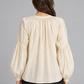 Blusa panna con scollo arricciato e laccetti, lunghe maniche morbide – retro su modella