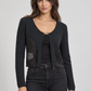 Cardigan nero cropped con pannelli traforati e piccola chiusura dorata – fronte su modella