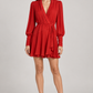 Abito Pinko rosso con scollo incrociato e polsini arricciati — fronte su modella (immagine generata con AI)