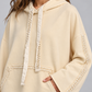 Felpa donna HAVEONE panna con cappuccio e perle, dettaglio su modella, elaborata con IA