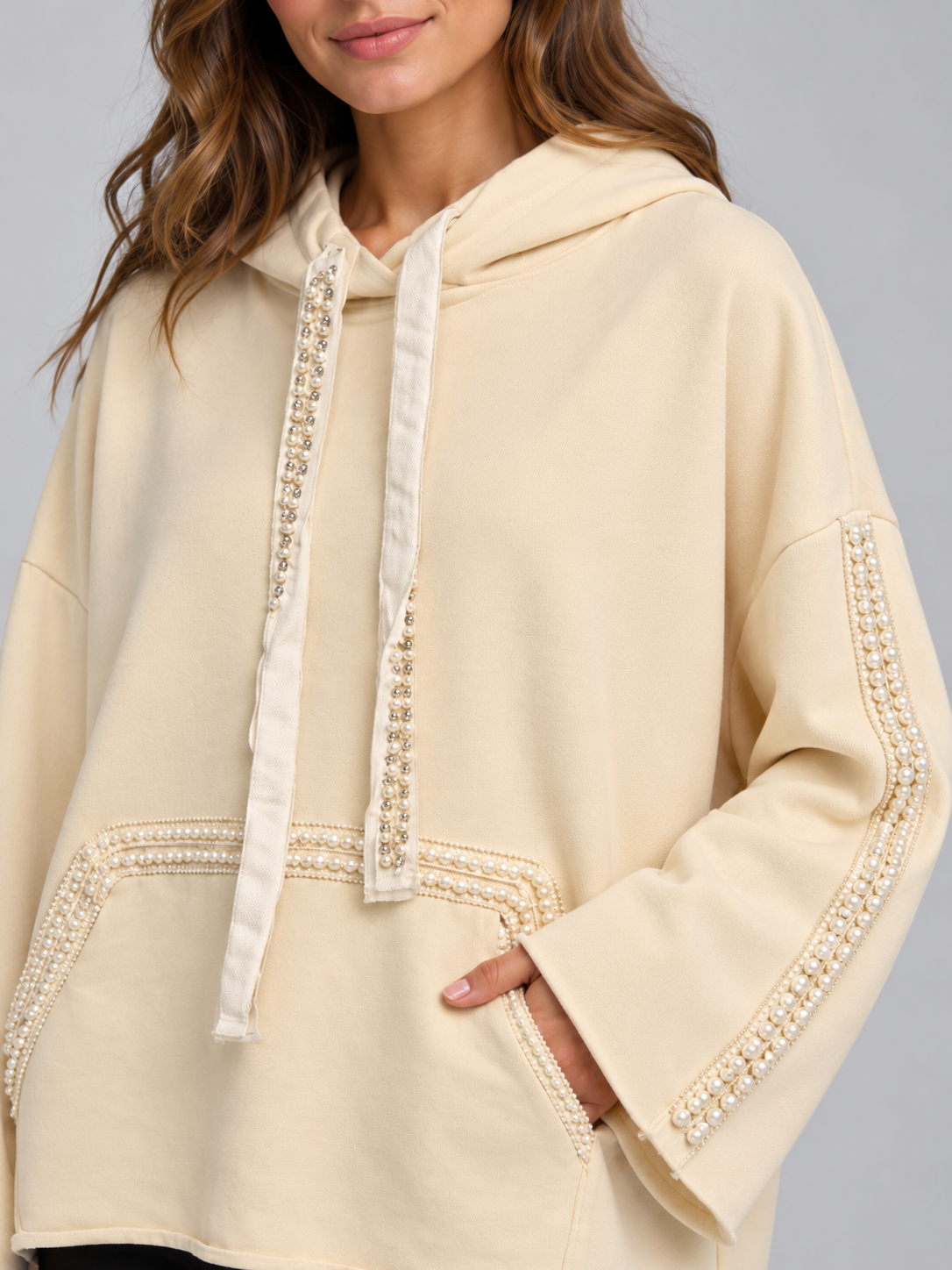 Felpa donna HAVEONE panna con cappuccio e perle, dettaglio su modella, elaborata con IA