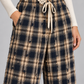 Pantalone donna Motel a quadri con pizzo, dettaglio su modella, elaborata con IA