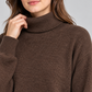Maglione donna HAVEONE marrone a collo alto, dettaglio su modella, elaborata con IA